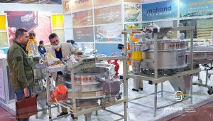 One of the members of Mahand's large sales and trading team is advising one of the visitors of the tile and ceramic exhibition about Vibrah's specialized sieves.